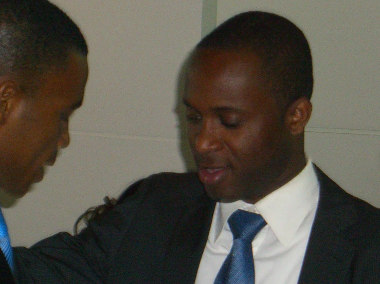 a black male in a blue tie and suit