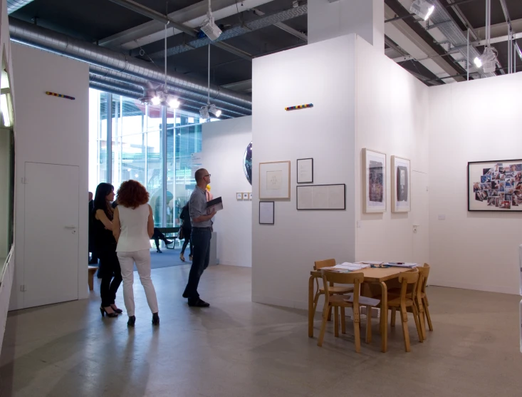 people standing around in a room near table and chairs