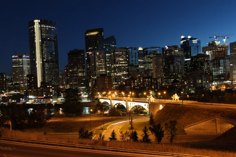 a highway leads to an underpass with tall buildings in the background