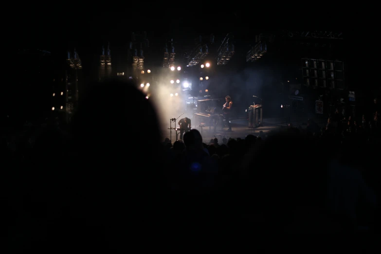 a crowd watches lights streaming on a stage