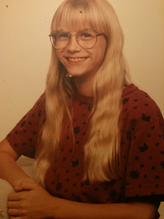 a young lady wearing glasses smiling for the camera