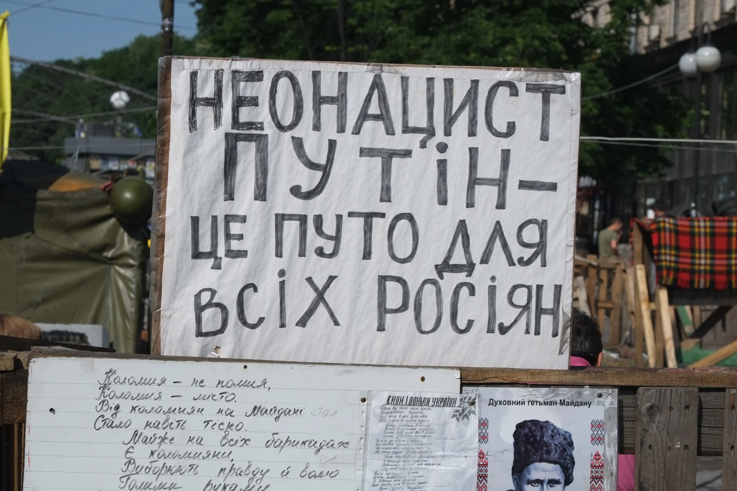 several large political signs, with writing and pictures of politicians and people