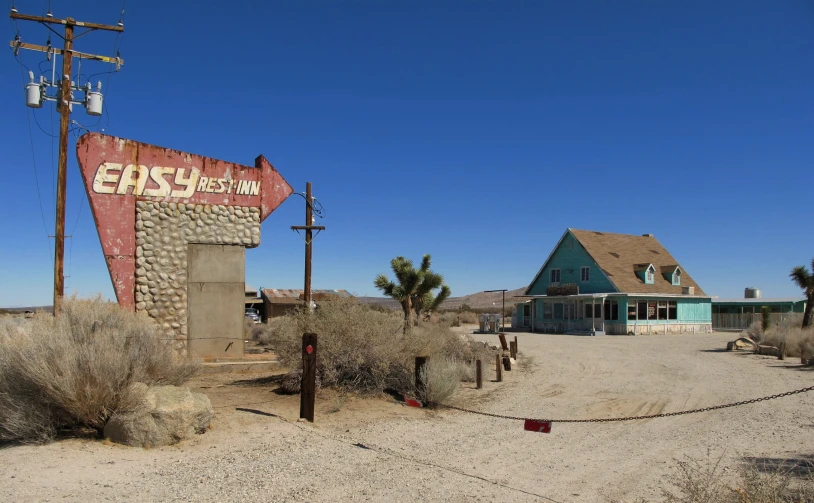 a very old motel sign and a building in the background