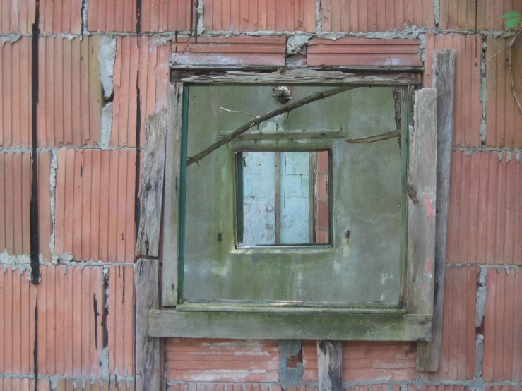 the inside of a brick wall with a window, and bird sitting on the nch