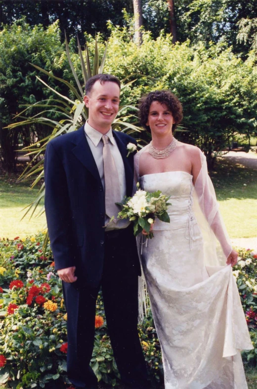 a married couple is posing together in their garden