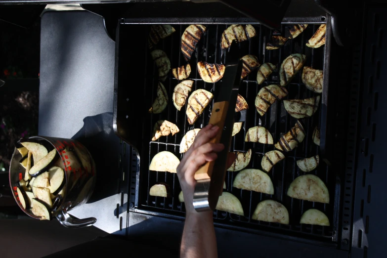 someone using an electric grill to cook apple slices