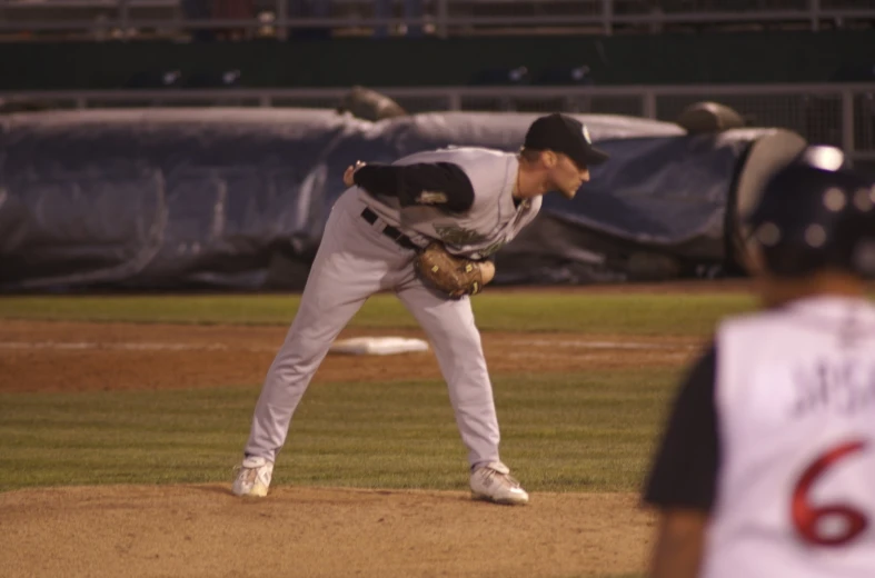 a baseball player has his mitt down as he gets ready to throw the ball
