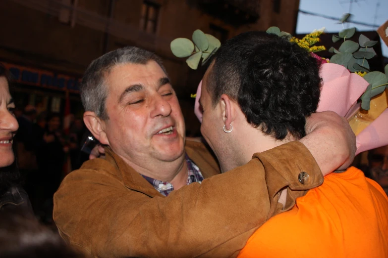 a man emcing his friend, while a woman in a jacket watches