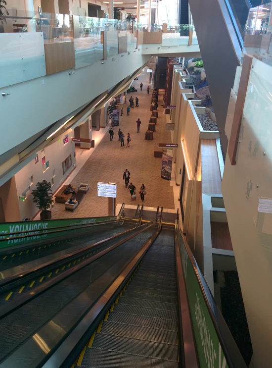 people walking through a building with escalators and stairs