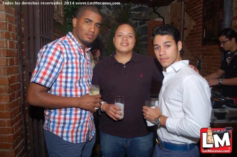 three young men posing for the camera at a night