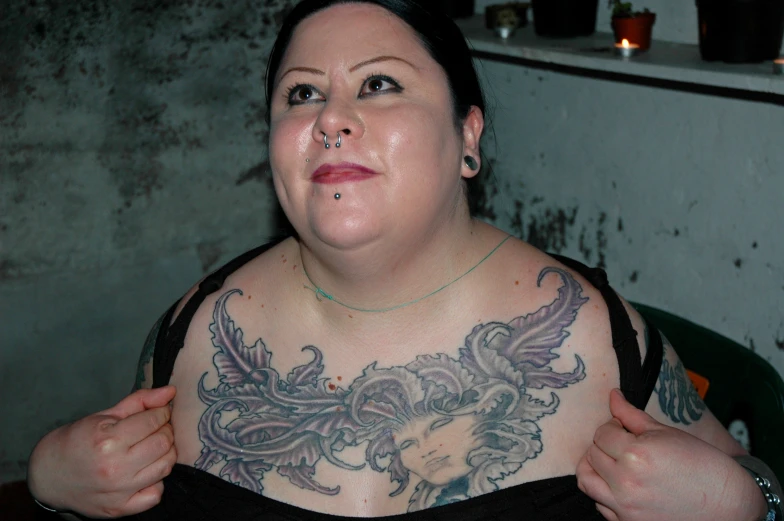 a woman with an attached gaggle and a tattoo on her body
