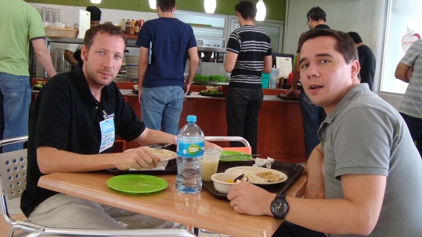 two people sitting at a table eating some food