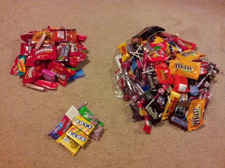 two piles of candy on a carpet and one pile of gum