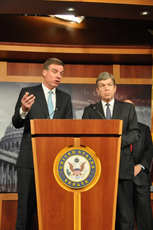 two people standing behind a podium that reads department