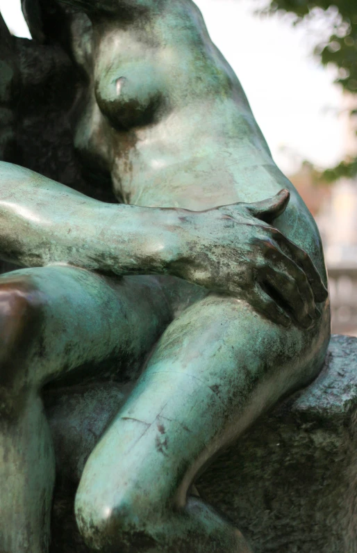 a statue of a female  sits on a rock