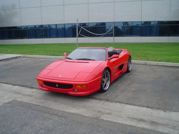 a red car sits parked in front of a building