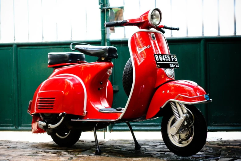 red motorcycle parked next to a wall with metal bars on it