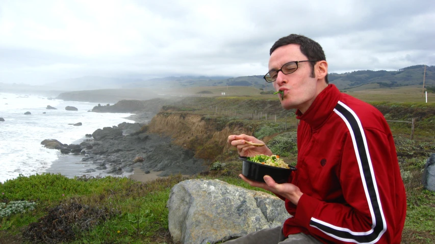 a man holding a bowl in his hand and a bowl with food in it