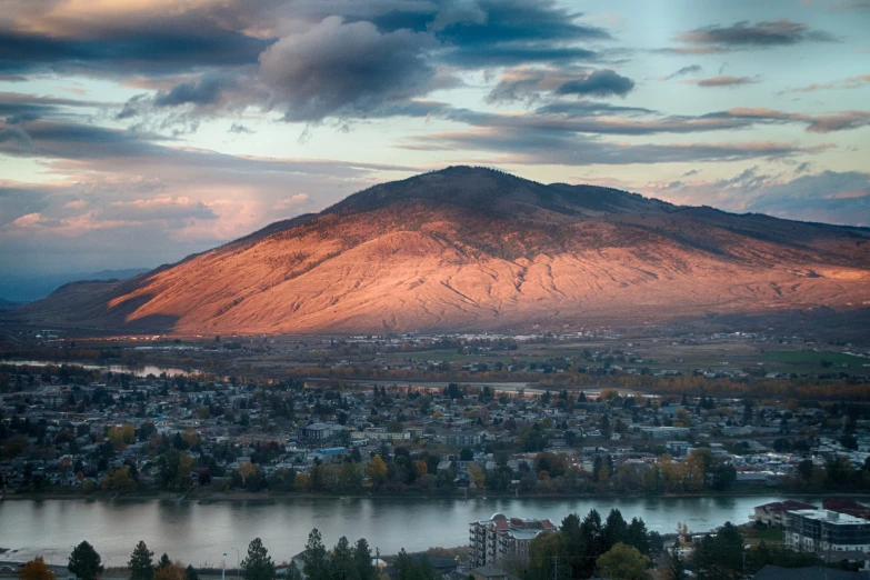 a river and mountain with houses next to it