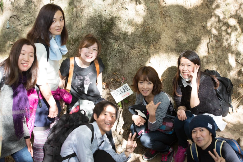 four asian people posing for a picture in front of a wall