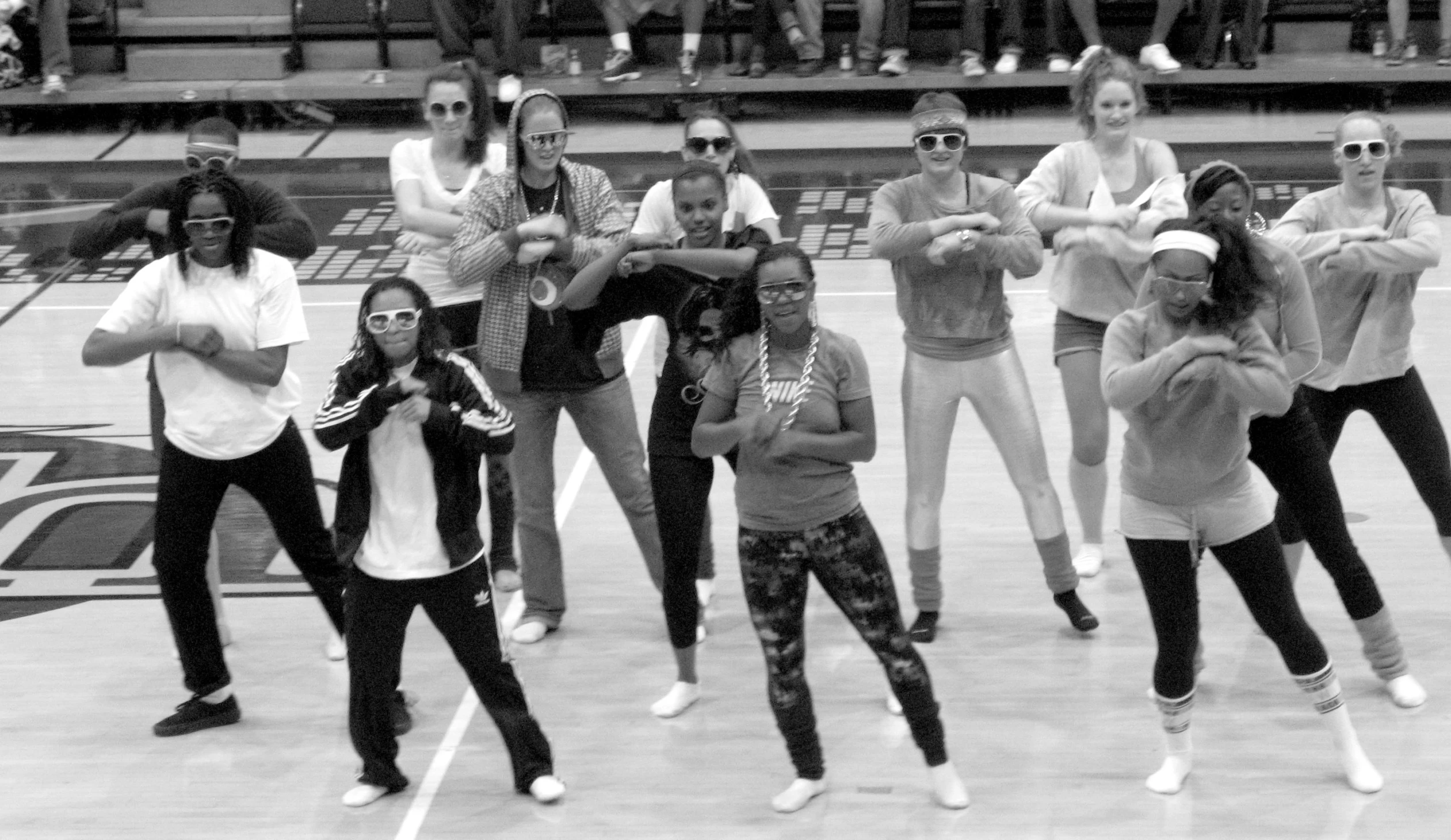 women and boys standing in front of a basketball court