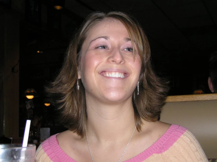 a young lady that is sitting down with a drink in hand