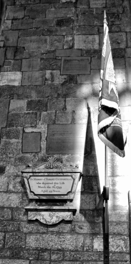 an old flag on top of the memorial at the side of a building