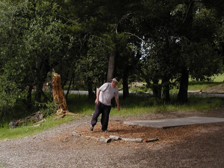 a man in a shirt and pants throws a frisbee