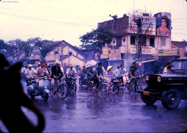several men riding bikes down the middle of a street