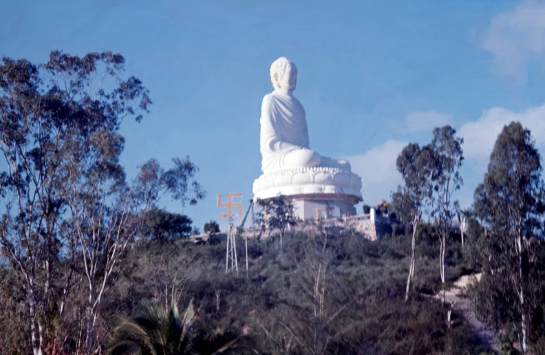 a big white statue that is on top of a hill