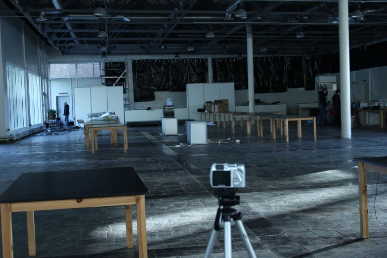 an empty building with lots of tables and chairs