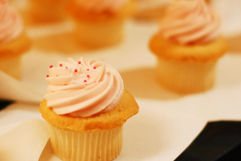 cupcakes on a table with pink frosting