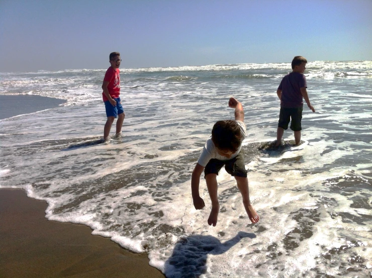 a group of people in the water playing on the beach