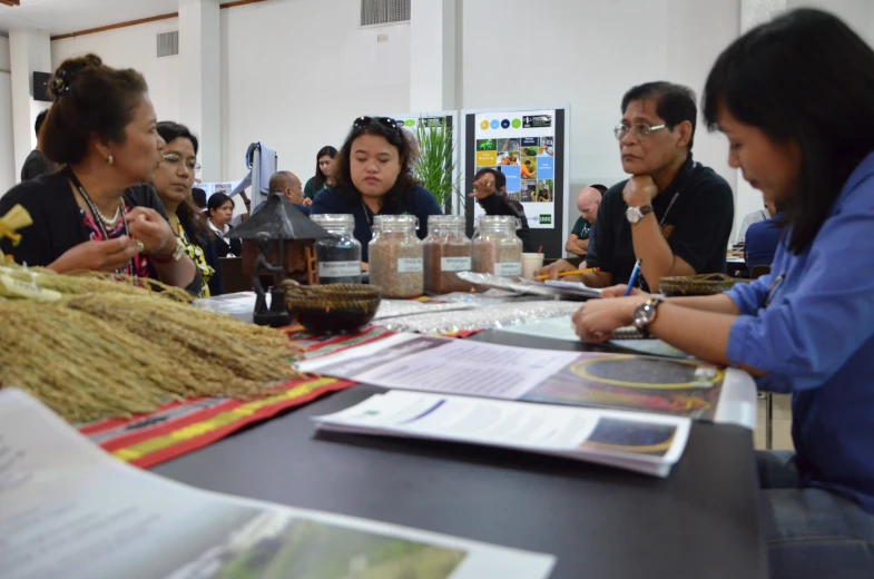 several people are gathered together at a long table