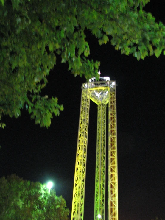 the night time view of a yellow tower