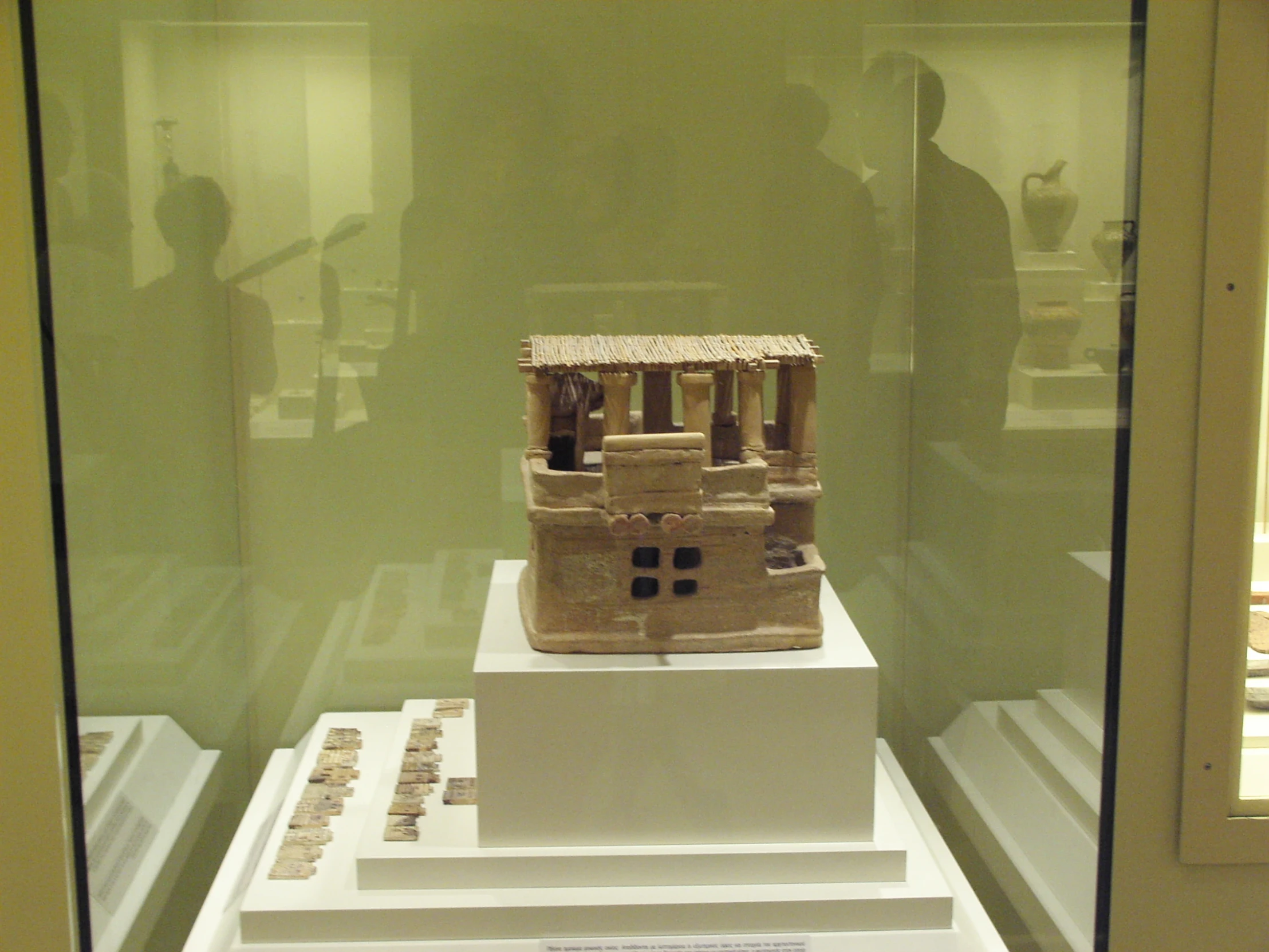 a clay model in a display case, on white platforms