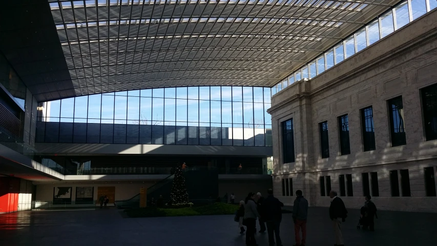 a courtyard area with several people walking around and a window with some light