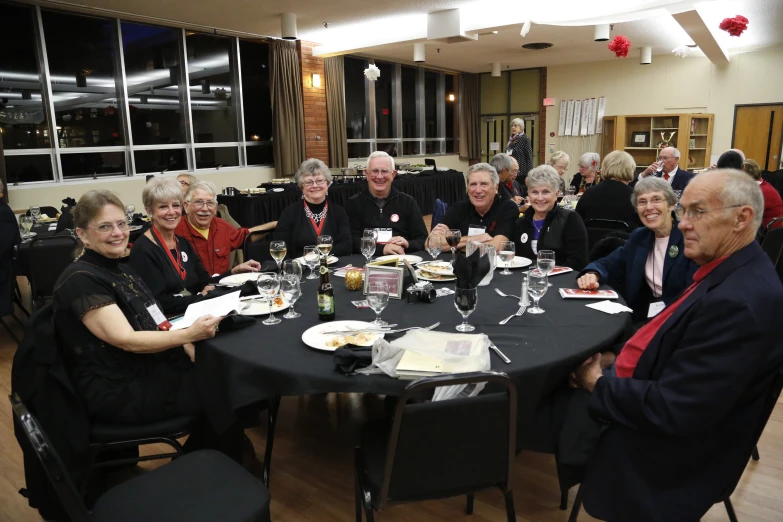 many older people sitting around a table eating