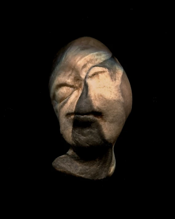 the head and eyes of a sculpture in dark lighting