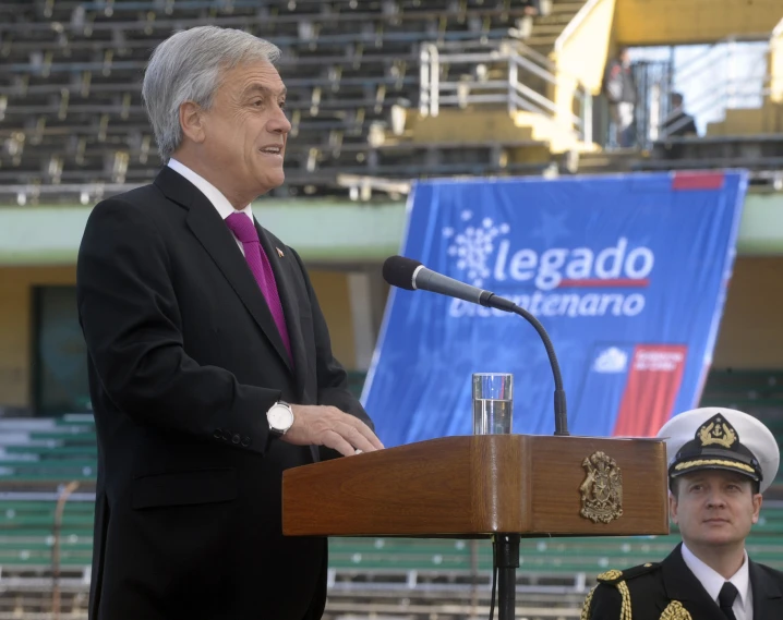 a man in a suit and tie is at a podium with microphone