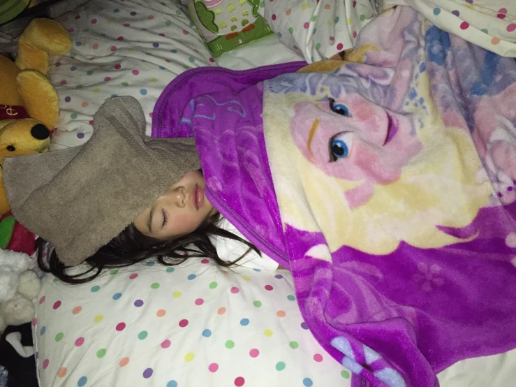 a girl is hiding her face under an oversize pink blanket