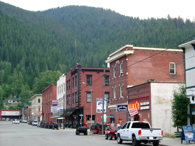 several cars are parked in the street as mountain range in the background