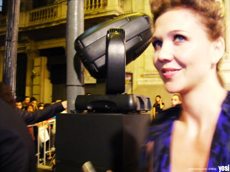 woman smiling for a camera taking picture of someone standing in front of her