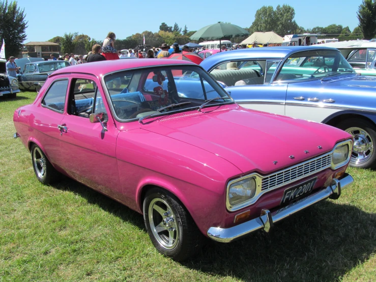 three cars are lined up and parked in a field