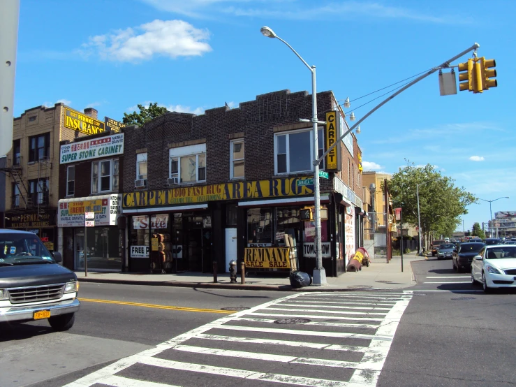 a city street with traffic lights, building, and cars