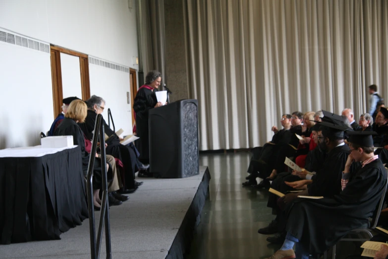 people sitting on chairs in front of the microphone, and wearing hats