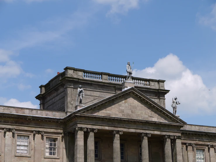 the roof of an old church with a statue on it