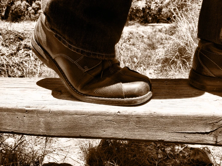 a black and white po of a foot on a wood slab