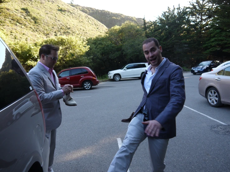 two men in suits standing next to each other outside