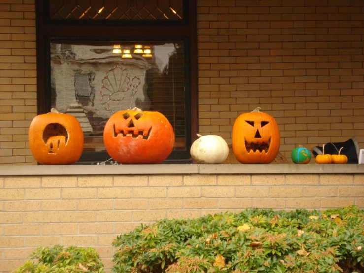 five carved pumpkins that are sitting in front of a window